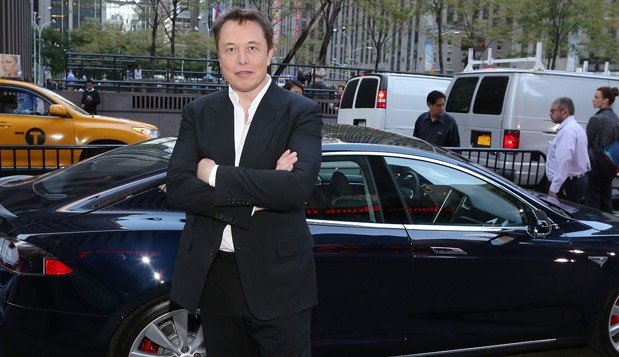 Pose de Elon Musk, em frente de um dos seus produtos (um Tesla Motors) demonstra confiança.